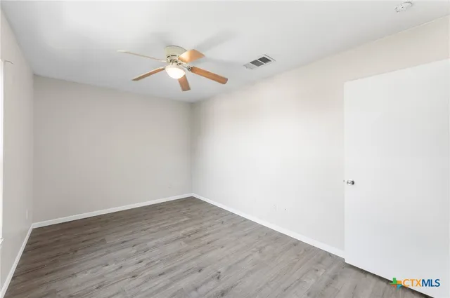 a view of an empty room with wooden floor