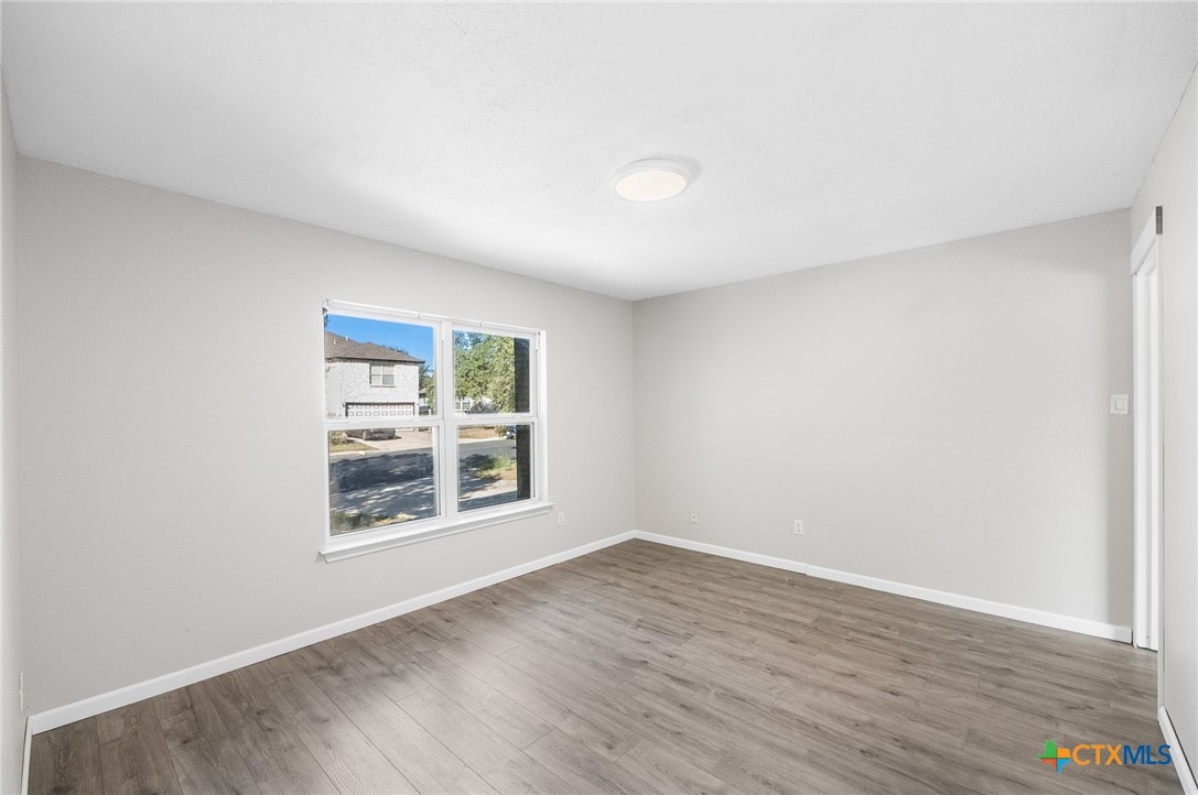 8010 Chestnut Gate Lane Converse, TX 78109 - Photo 30 of 35 an empty room with wooden floor and windows