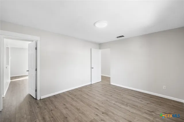 a view of an empty room with wooden floor