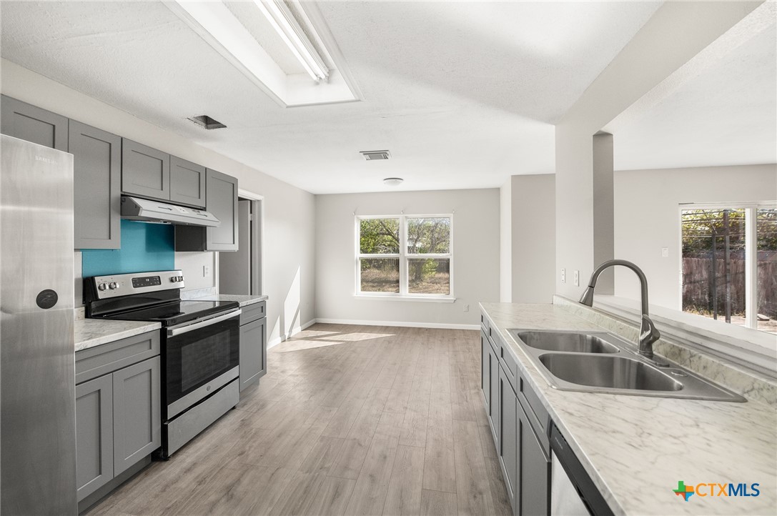 8010 Chestnut Gate Lane Converse, TX 78109 - Photo 8 of 35 a kitchen with stainless steel appliances granite countertop a sink a stove a refrigerator cabinets and a window