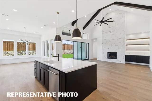 a view of a livingroom with a fireplace a ceiling fan and entryway