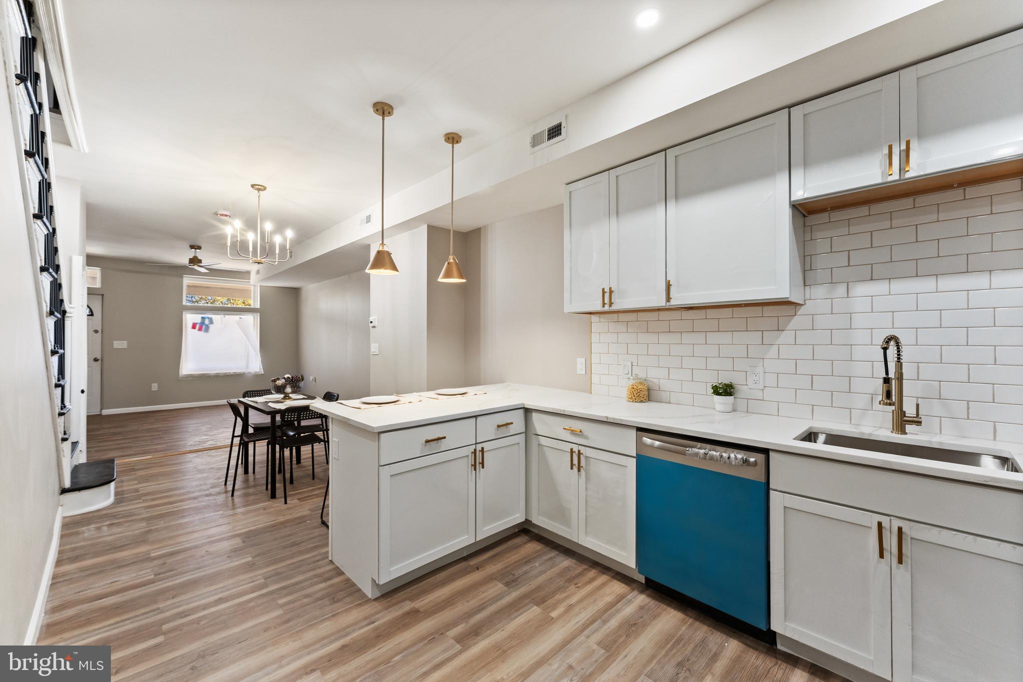 602 Denison Street Baltimore, MD 21229 - Photo 6 of 17 a kitchen with a sink stove and cabinets