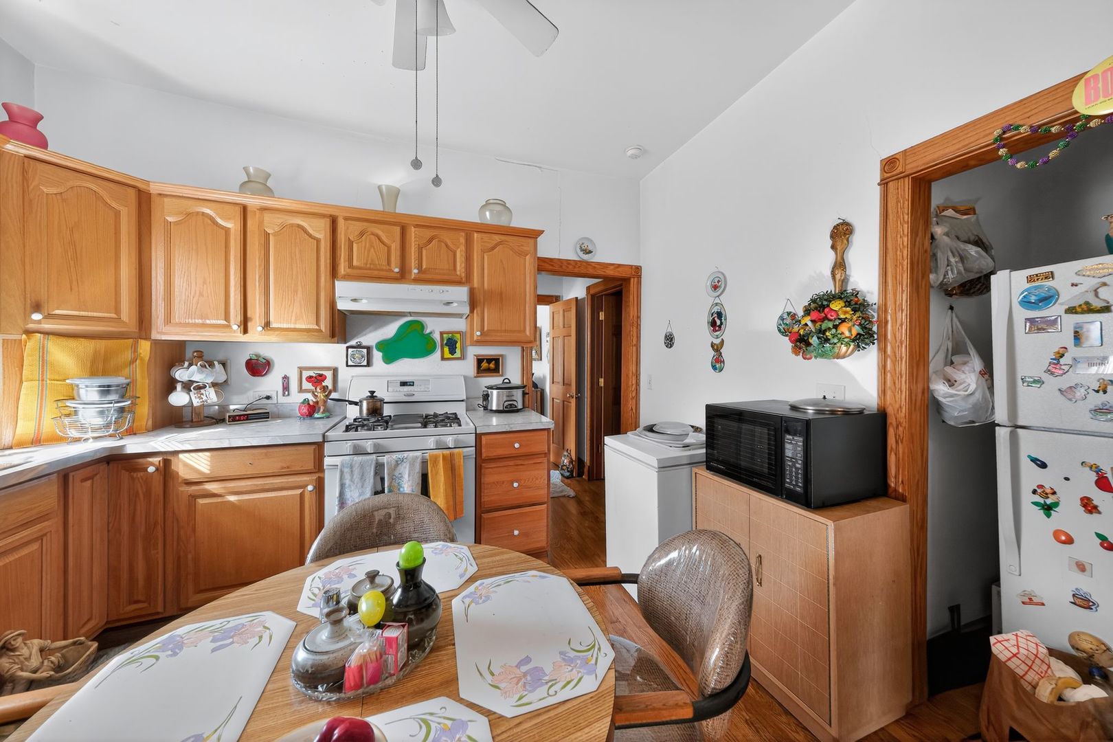 6541 South Carpenter Street Chicago, IL 60621 - Photo 12 of 27 a kitchen with stainless steel appliances a stove a refrigerator a sink a dining table and chairs with wooden floor