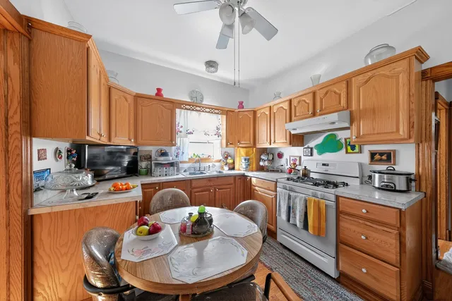 a kitchen with stainless steel appliances granite countertop a stove top oven a sink dishwasher and cabinets with wooden floor