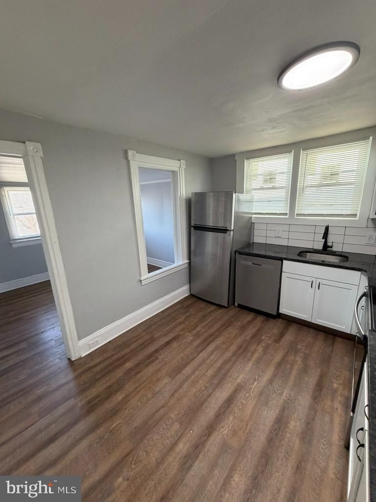 1410 Huddell Avenue Marcus Hook, PA 19061 - Photo 20 of 29 a view of a kitchen and an empty room with wooden floor and a window