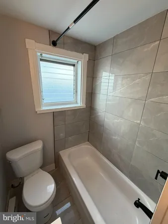 a white toilet sitting next to a bath tub