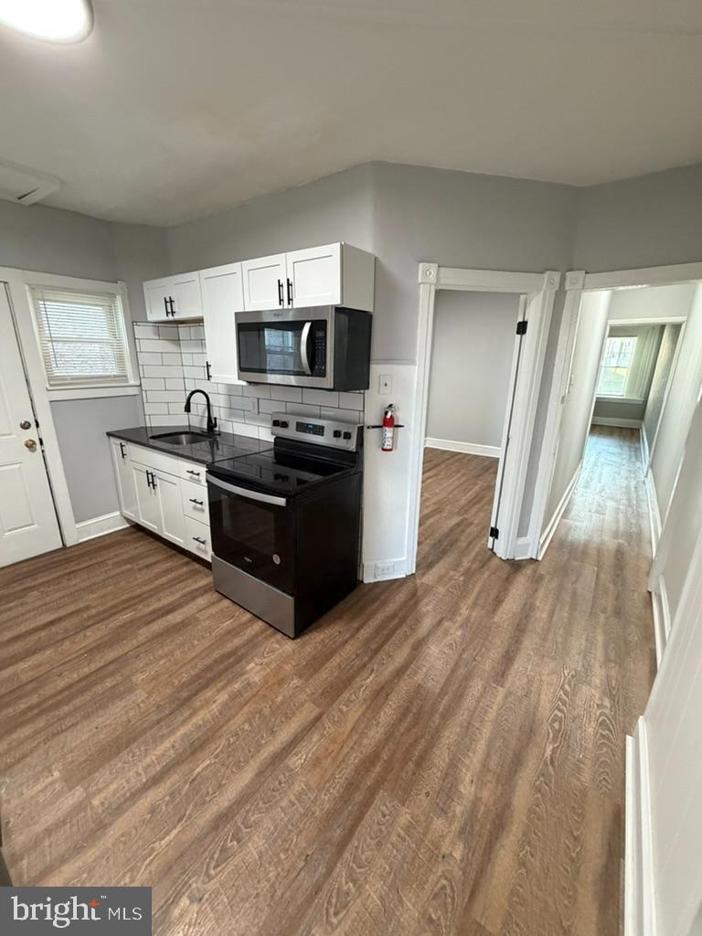 1410 Huddell Avenue Marcus Hook, PA 19061 - Photo 6 of 29 a kitchen with stainless steel appliances wooden floor and a refrigerator