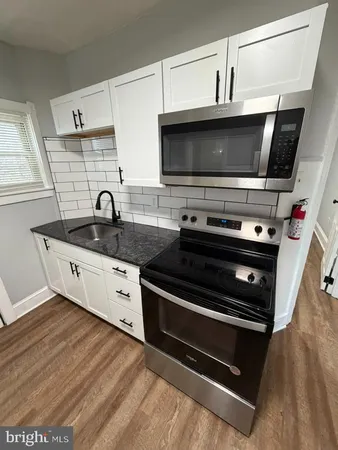 a kitchen with stainless steel appliances a stove a microwave and sink