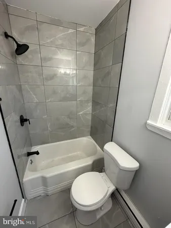 a bathroom with a toilet and a bath tub
