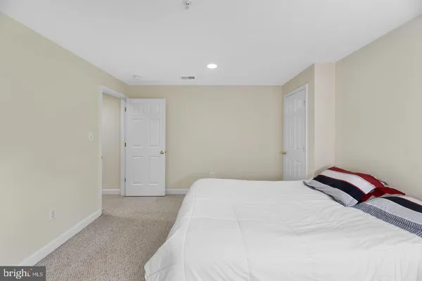 a bedroom with a bed and a lamp on desk