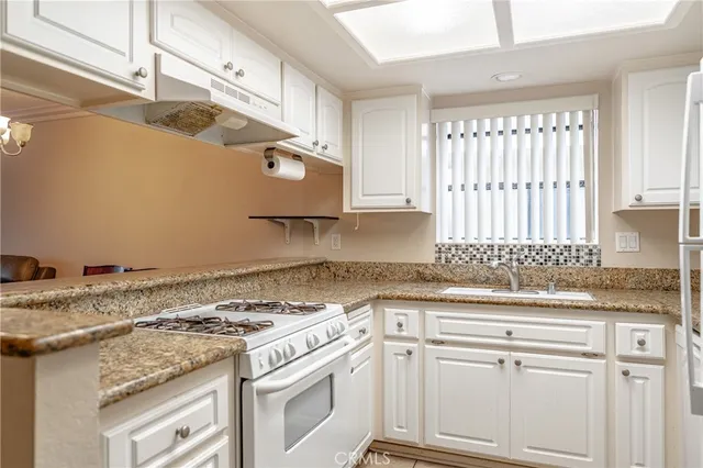 a kitchen with granite countertop a refrigerator and a sink