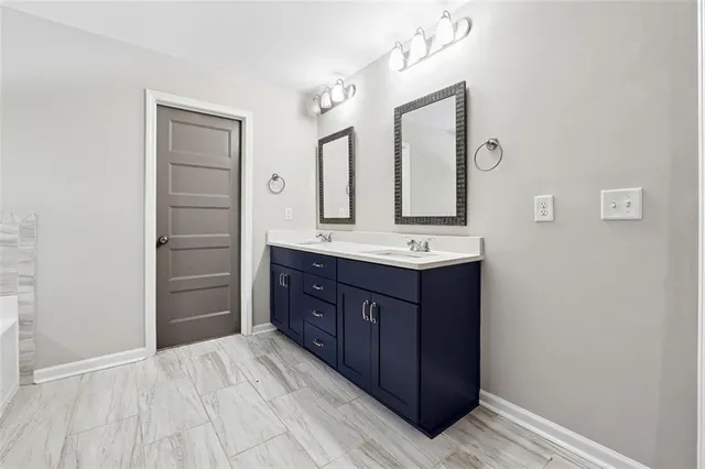 a bathroom with a vanity a sink a mirror and a shower