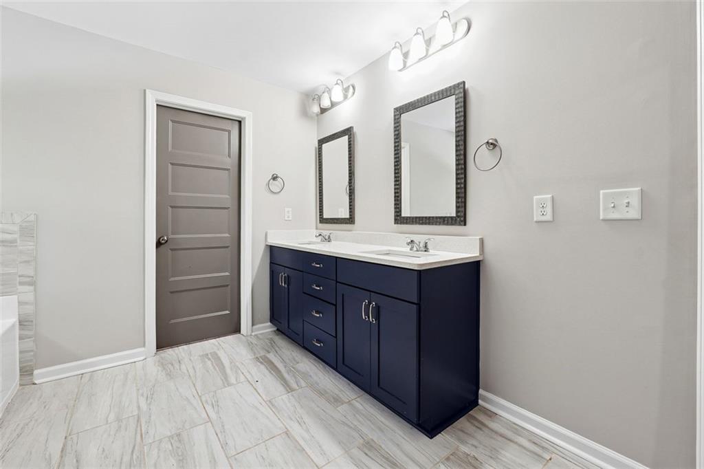 528 Clinton Drive Temple, GA 30179 - Photo 15 of 25 a bathroom with a vanity a sink a mirror and a shower