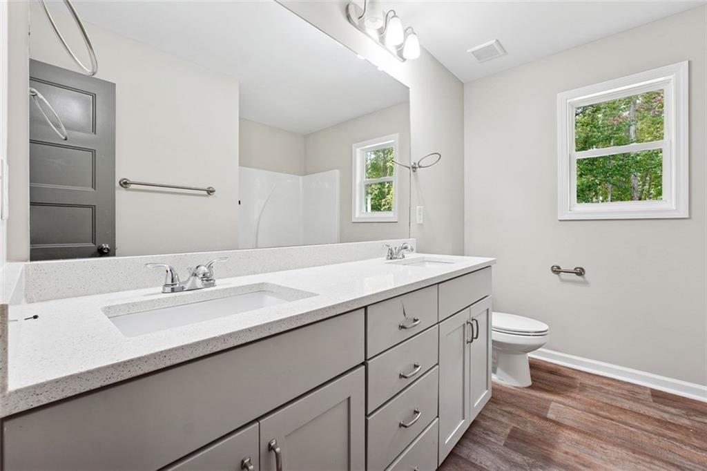 528 Clinton Drive Temple, GA 30179 - Photo 21 of 25 a bathroom with a double vanity sink toilet and a window