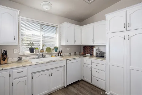 a kitchen with white cabinets and white appliances