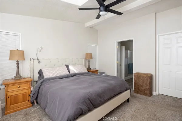 a bedroom with a bed and dresser with mirror