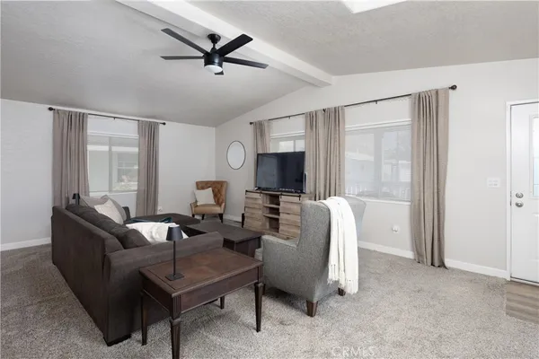 a living room with furniture a ceiling fan and a window