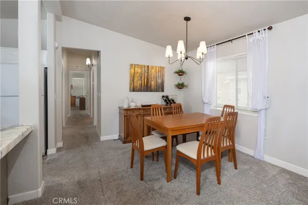 a view of a dining room with furniture and chandelier