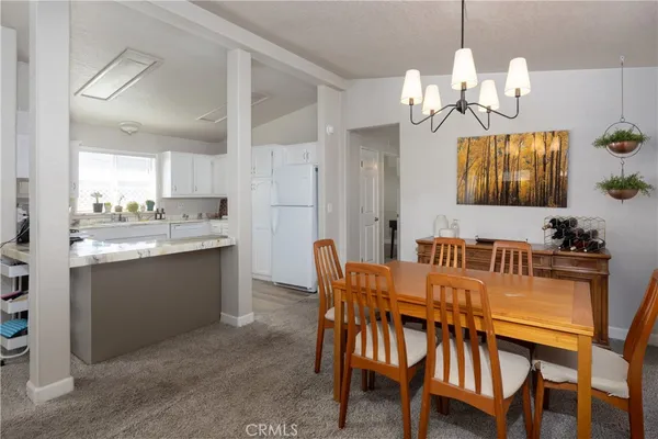 a view of a dining room with furniture and chandelier