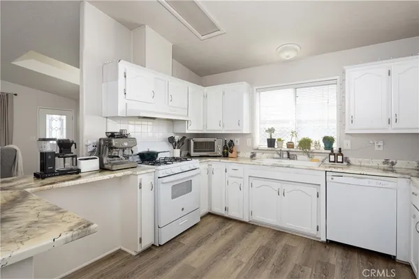 a kitchen with cabinets appliances a sink and a window