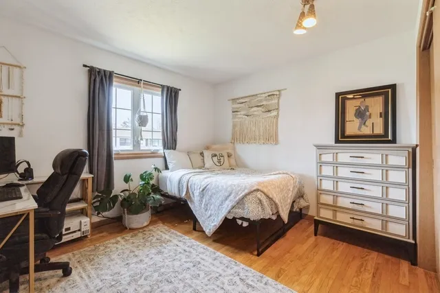 a bedroom with a bed and a dresser next to a window