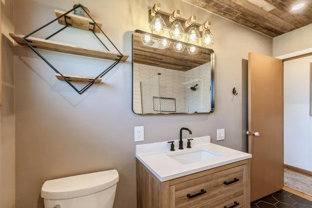 a bathroom with a sink a toilet and mirror