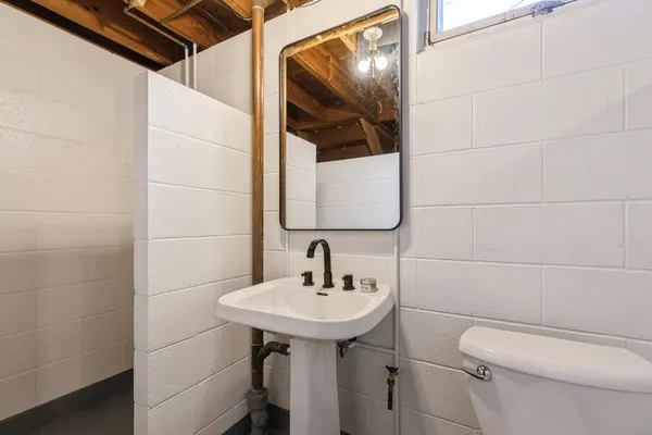 a bathroom with a toilet sink and mirror