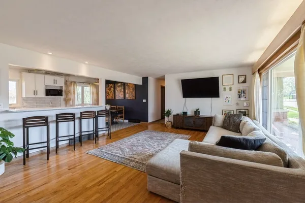 a living room with furniture wooden floor and a flat screen tv