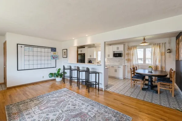 a living room with furniture wooden floor and a large window