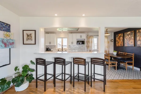 a kitchen with stainless steel appliances kitchen island granite countertop a table and chairs in it