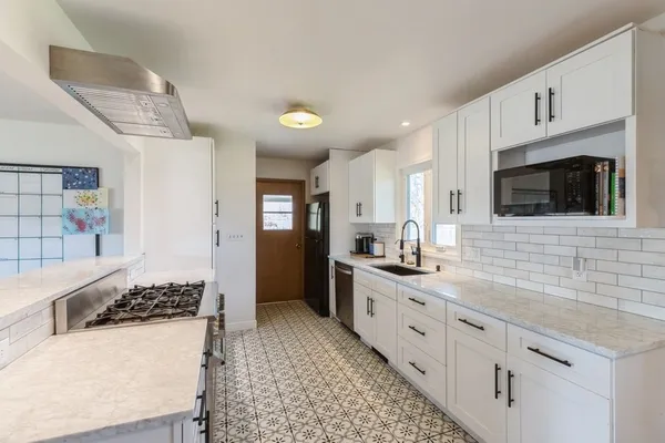 a kitchen with stainless steel appliances kitchen island granite countertop a sink and a stove