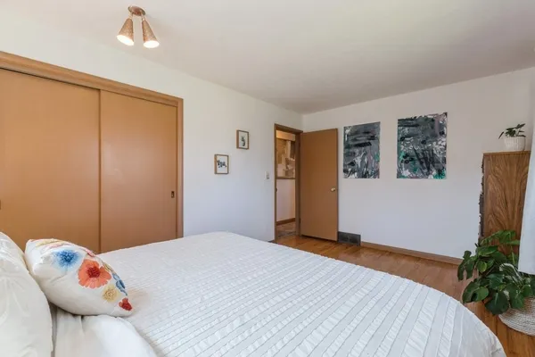 a bedroom with a bed and a potted plant