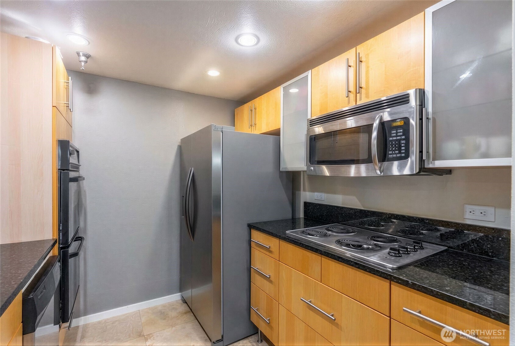 975 Aberdeen Avenue Northeast, Unit F207 Renton, WA 98056 - Photo 10 of 24 a kitchen with stainless steel appliances granite countertop a refrigerator and a stove top oven