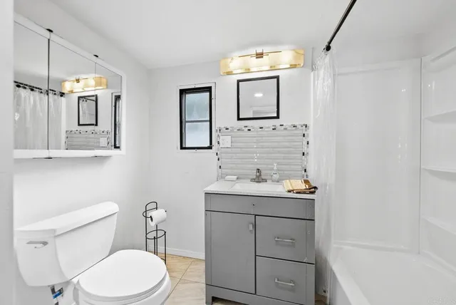 a bathroom with a toilet a sink a bath tub and mirror