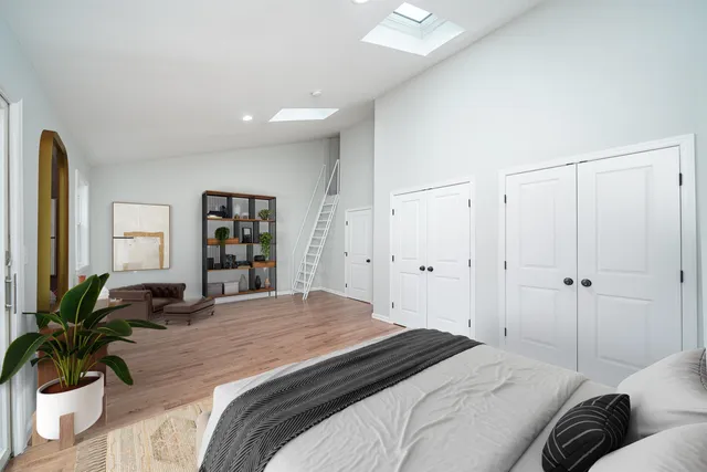 a bedroom with a large bed and a potted plant