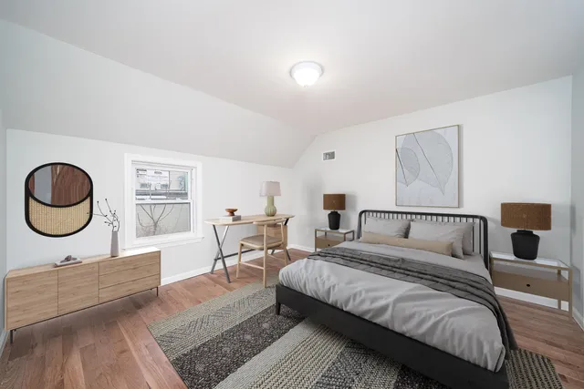 a spacious bedroom with a bed a window and dresser