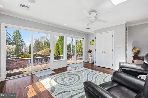 a view of a dining room and livingroom with furniture wooden floor kitchen chandelier