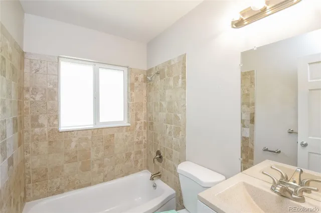a bathroom with a sink and bathtub with toilet
