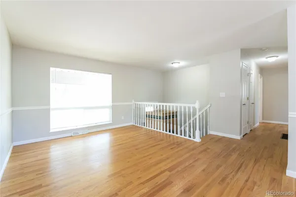 a view of a room with wooden floor and a window