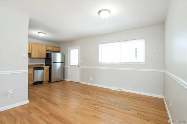 a view of a kitchen with wooden floor electronic appliances and windows