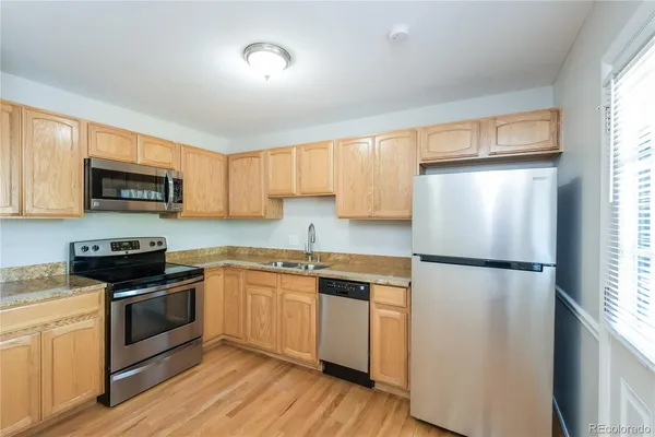 a kitchen with a refrigerator a stove top oven a sink and cabinets