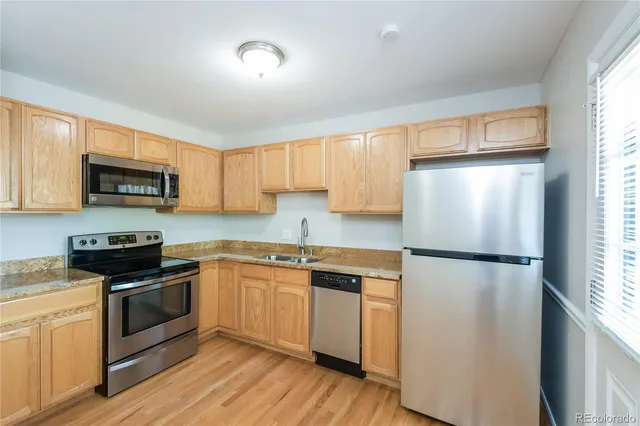 a kitchen with a refrigerator a stove top oven a sink and cabinets