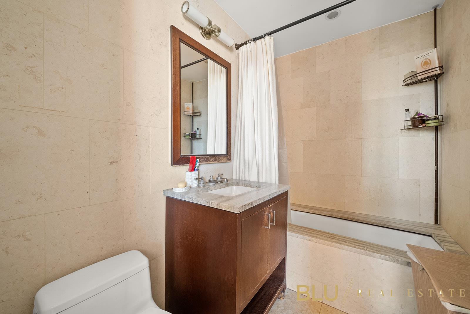 100 Riverside Boulevard, Unit 28E Manhattan, NY 10069 - Photo 4 of 6 a bathroom with a granite countertop sink a toilet and shower