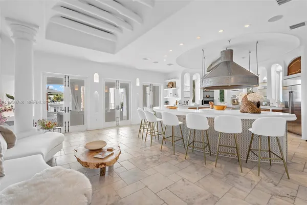 a living room with furniture a table and kitchen view