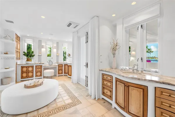 a large bathroom with a granite countertop sink a mirror a bathtub and shower