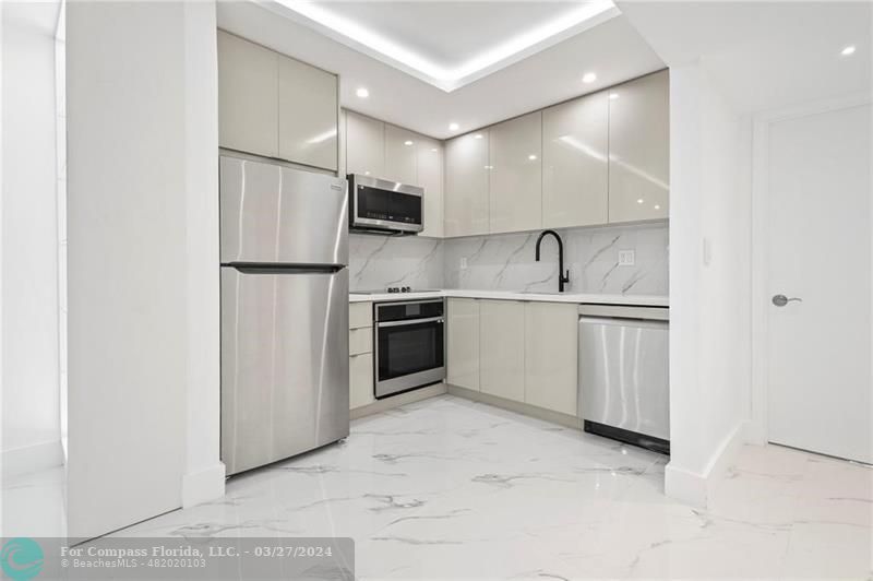 a kitchen with white cabinets and white appliances