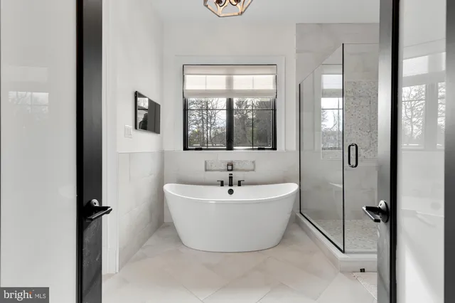 a bathroom with a white bath tub sitting next to a window