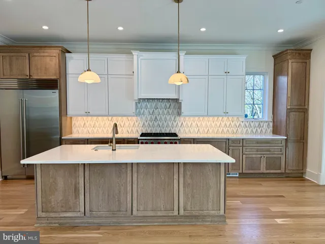 a kitchen with kitchen island granite countertop a sink a refrigerator and a stove