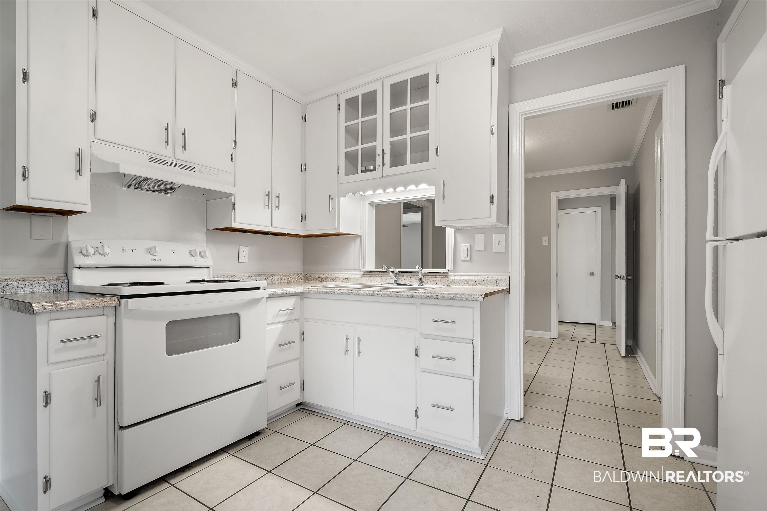 963 Shady Brook Drive Mobile, AL 36606 - Photo 7 of 20 Kitchen with white appliances, under cabinet range hood, crown molding, a sink, and light countertops