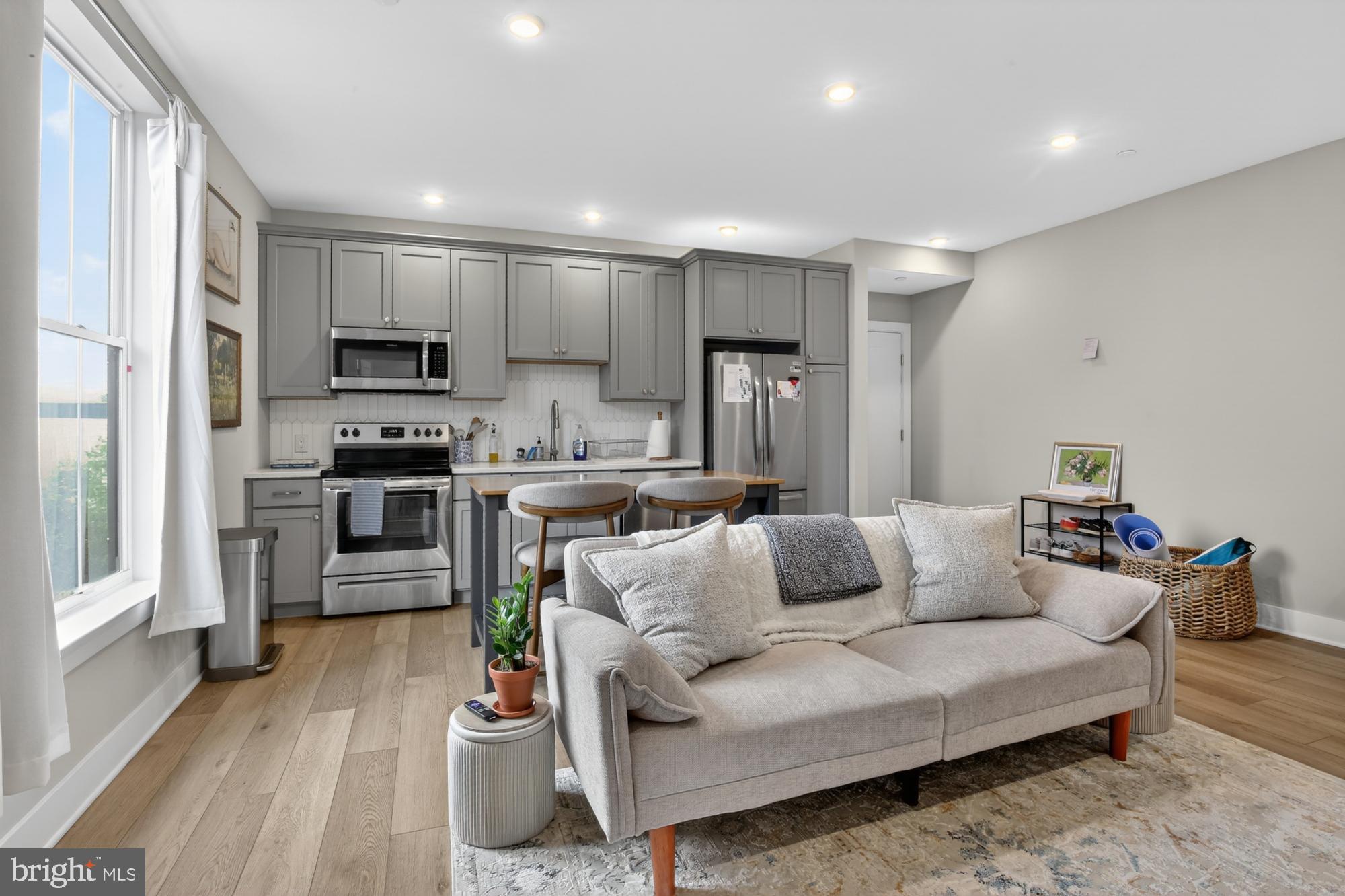 6712 Ridge Avenue, Unit 203 Philadelphia, PA 19128 - Photo 4 of 16 a living room with stainless steel appliances furniture and a wooden floor